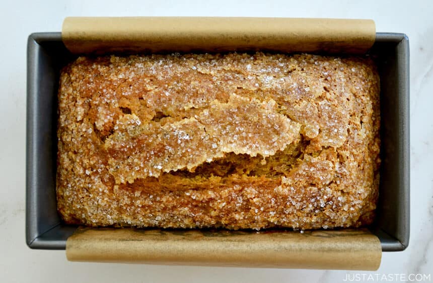 A top-down view of a bread pan containing easy Pumpkin Banana Bread topped with sanding sugar