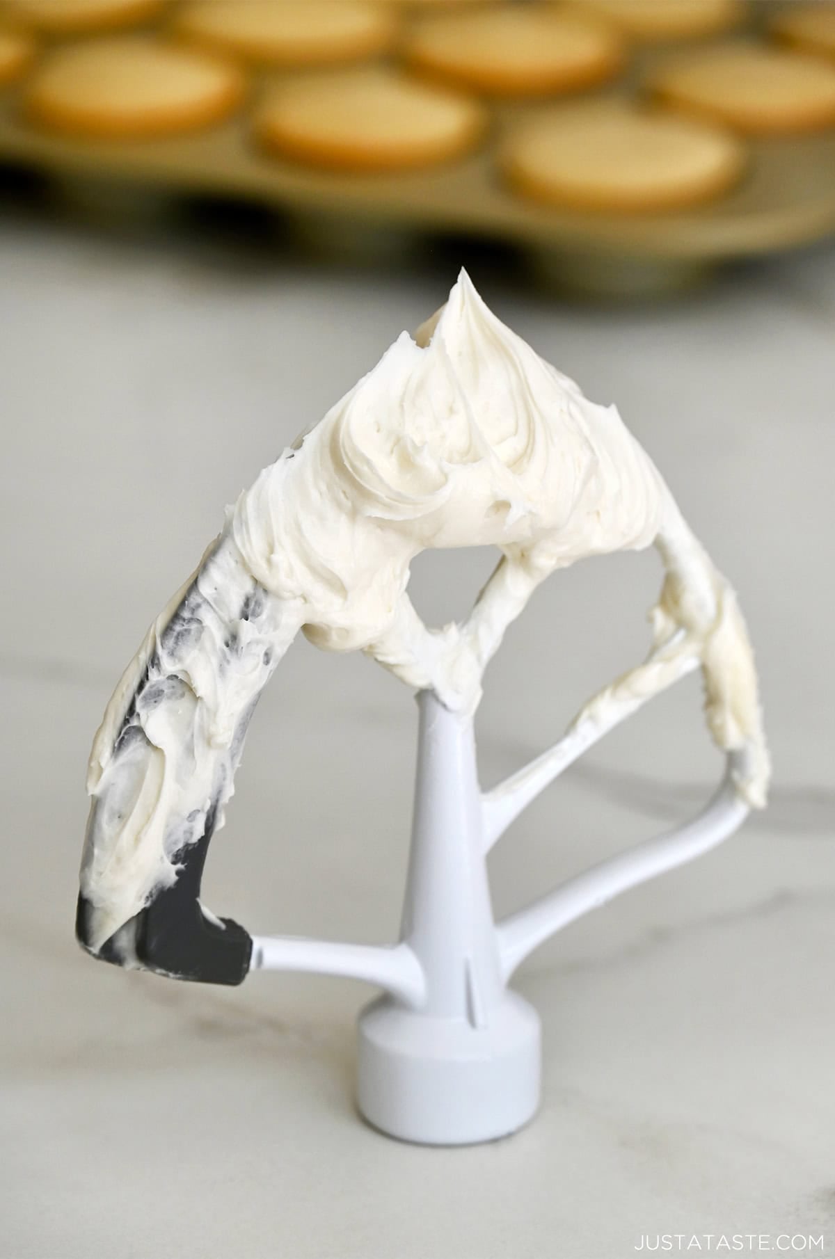 Super-white, fluffy vanilla buttercream frosting on the paddle attachment of a stand mixer.