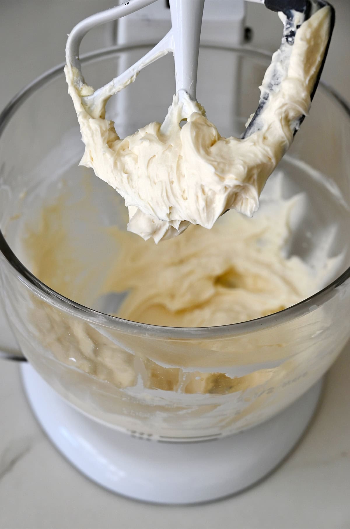 Vanilla buttercream frosting on a stand mixer paddle attachment showing the natural ivory color of American buttercream.