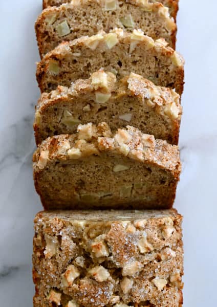A top-down view of a half-sliced loaf of Apple Cinnamon Banana Bread