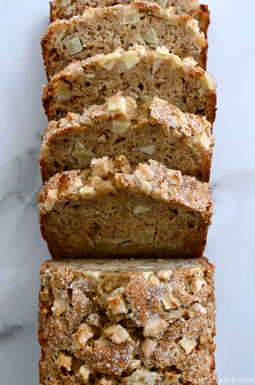 A top-down view of a half-sliced loaf of Apple Cinnamon Banana Bread