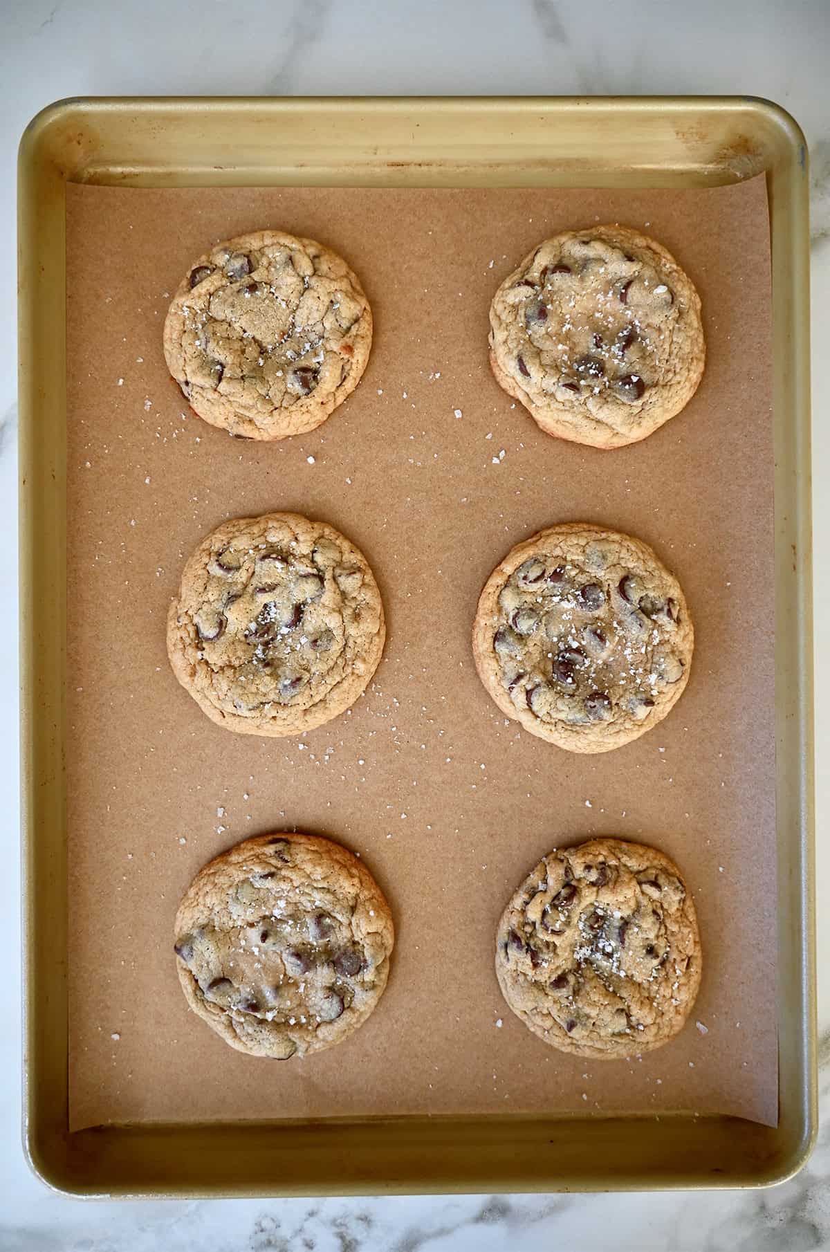 Freshly baked caramel cookies on a parchment paper-lined baking sheet.