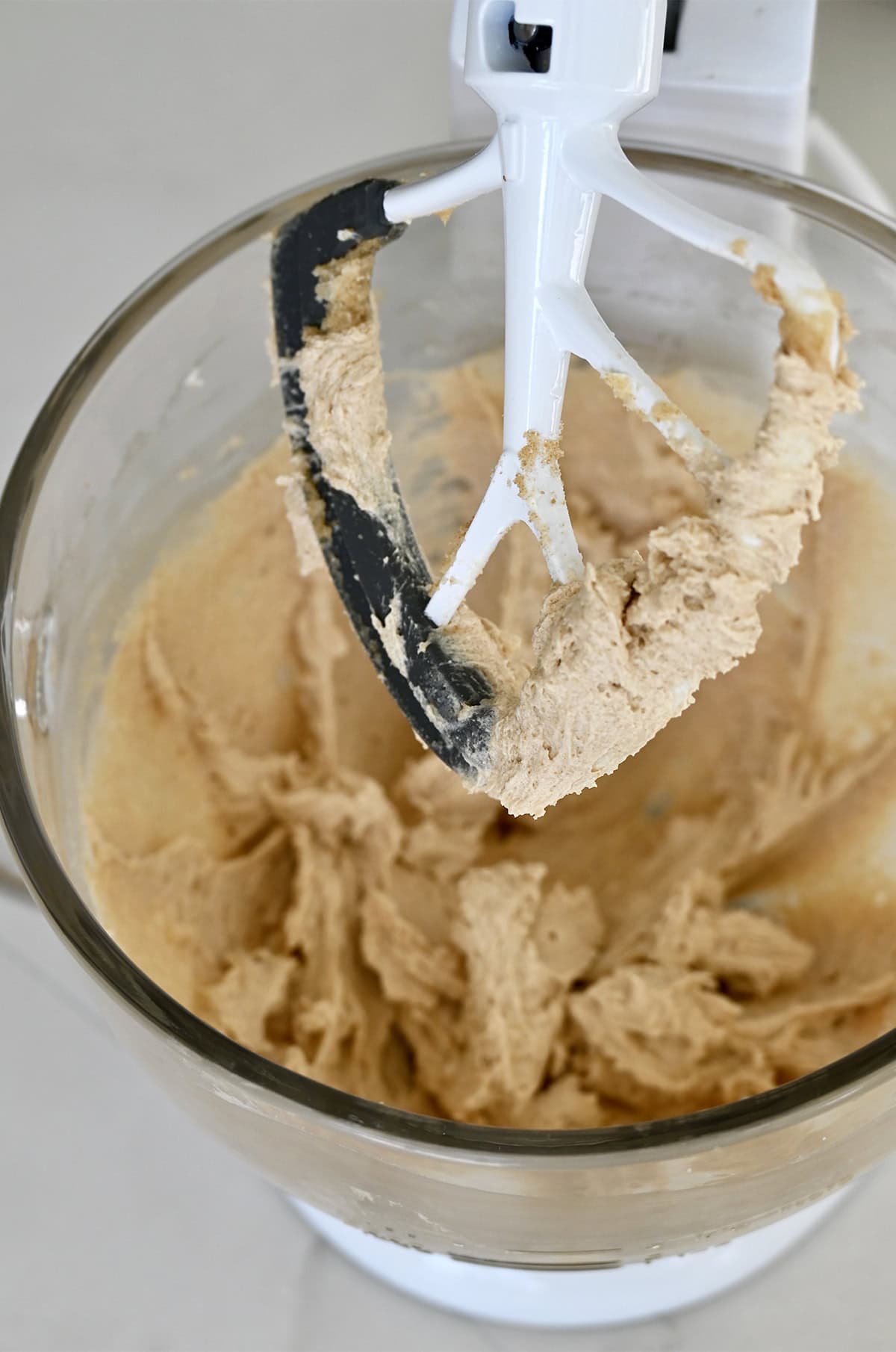 Creamed butter with granulated and light brown sugars in a bowl of a stand mixer with the paddle attachment.