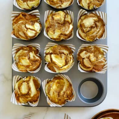 A muffin tin containing Cream Cheese Pumpkin Muffins