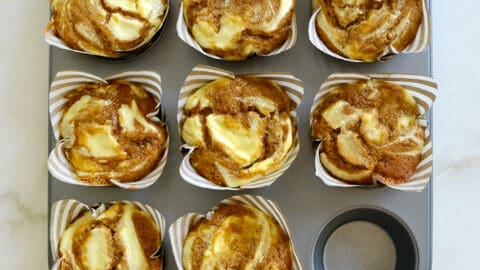 A muffin tin containing Cream Cheese Pumpkin Muffins