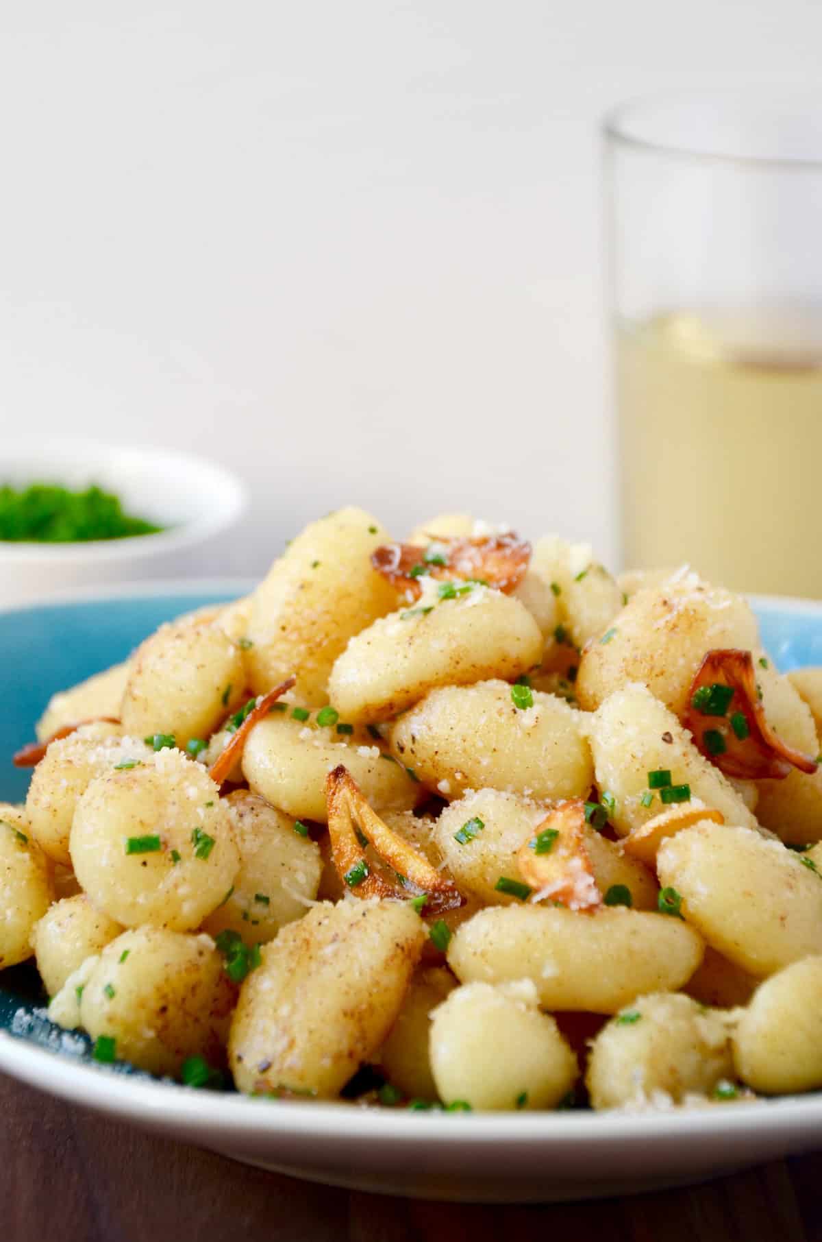 Gnocchi with garlic and parmesan cheese piled high on a plate.