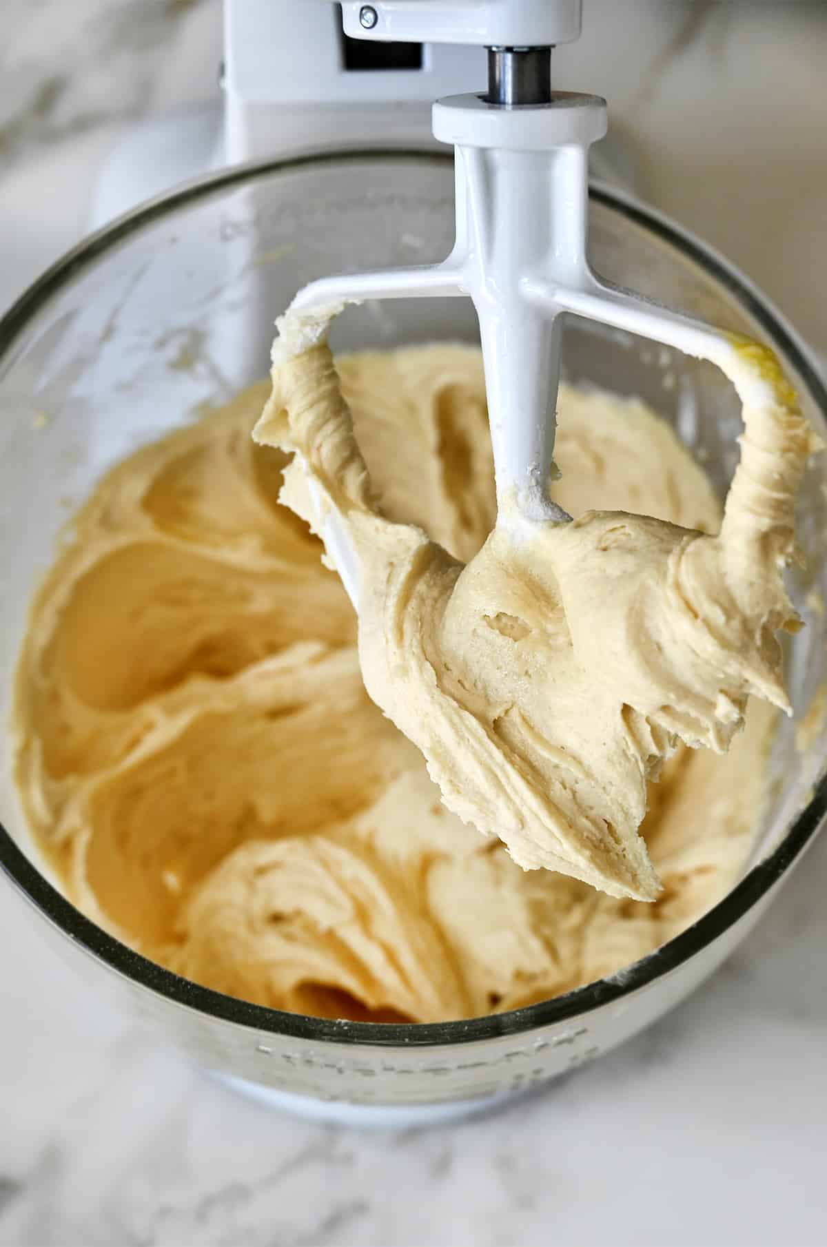 Sugar cookie bars dough in a stand mixer with the paddle attachment. 