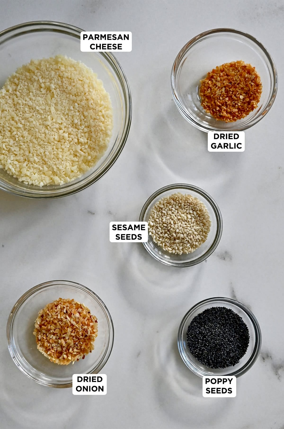 Ingredients to make baked Parmesan cheese crisps in various sizes of glass mixing bowls.