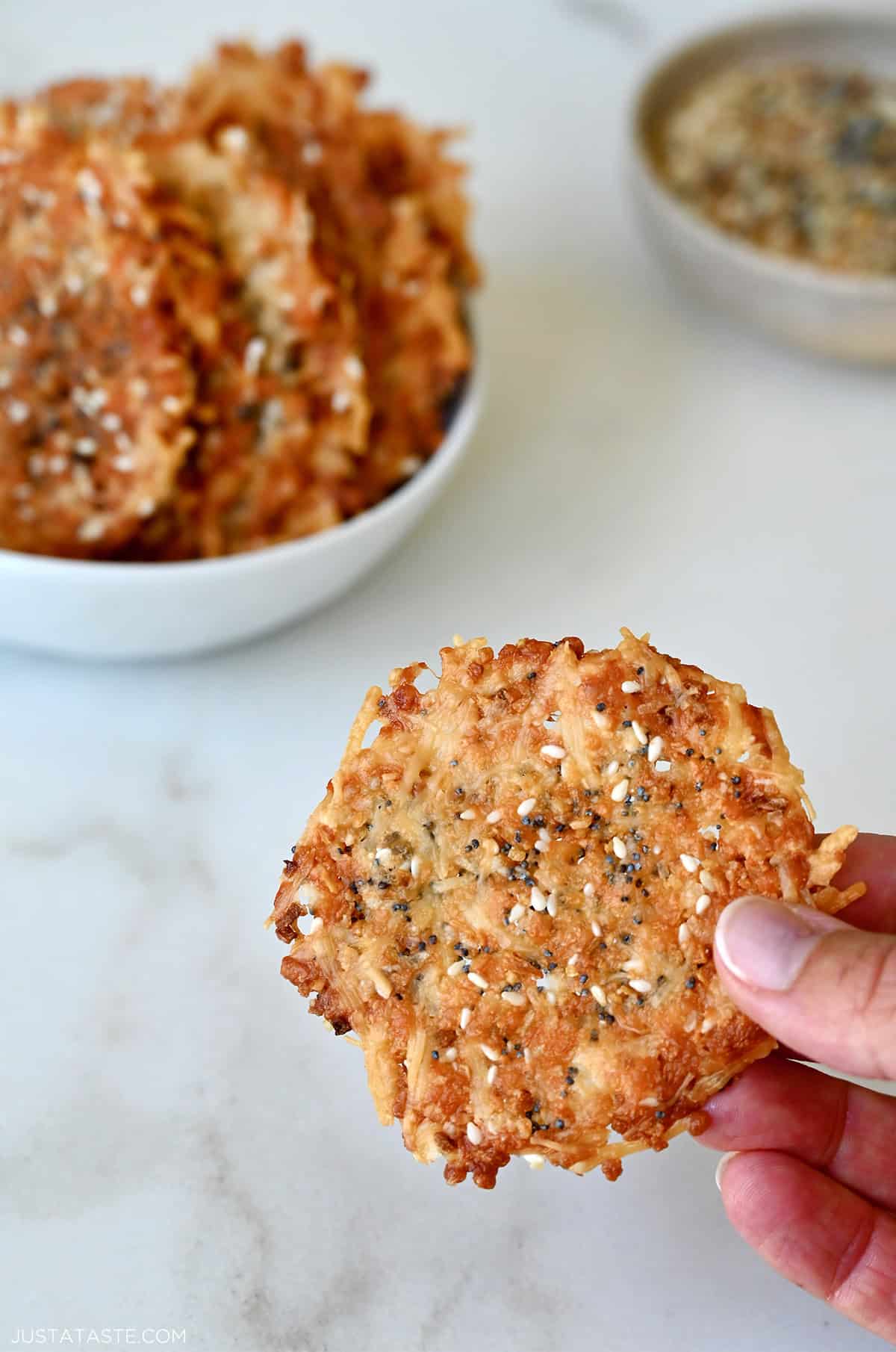Hand holding a crispy Parmesan cheese crisp.