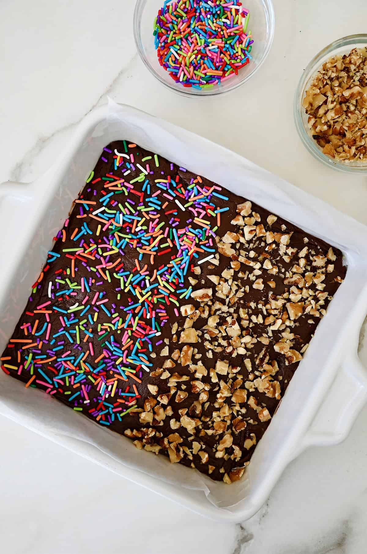 Chocolate fudge with two different toppings, rainbow sprinkles and chopped walnuts.