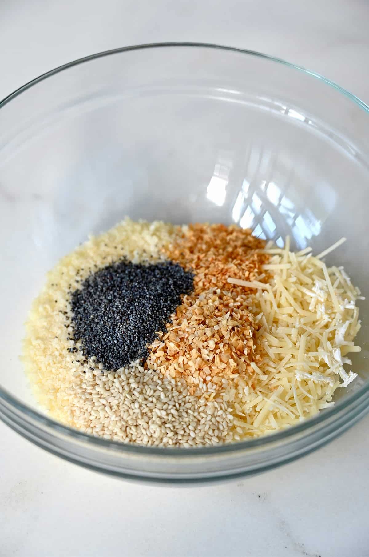 Shredded and grated Parmesan cheese, along with everything seasoning in a bowl.