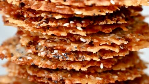 A tall stack of baked Parmesan cheese crisps with everything bagel seasoning.