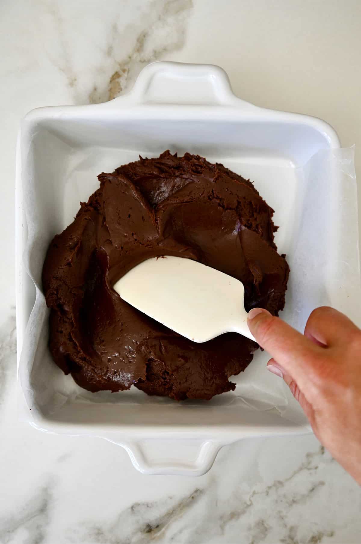 Spreading microwave fudge into a square pan.