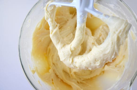 Silky buttercream frosting in stand mixer bowl with paddle attachment