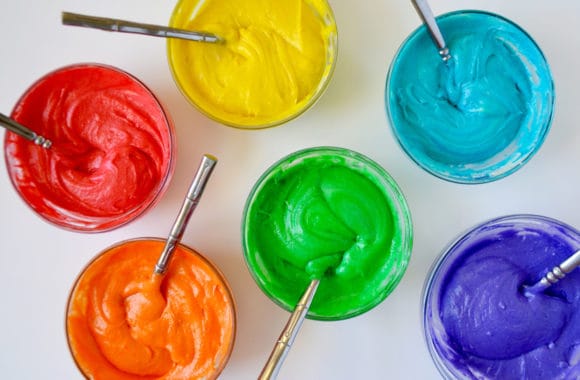 Six bowls containing various colors of cupcake batter