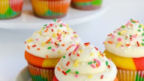 Rainbow Cupcakes with Buttercream Frosting and sprinkles on white plate