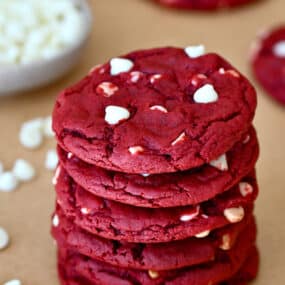 A stack of red velvet cookies studded with white chocolate chips.
