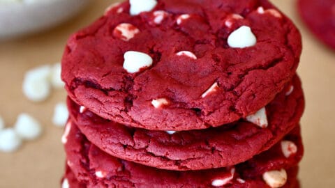 A stack of red velvet cookies studded with white chocolate chips.