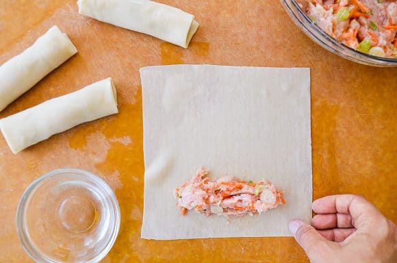 An egg roll wrapped being filled and rolled up