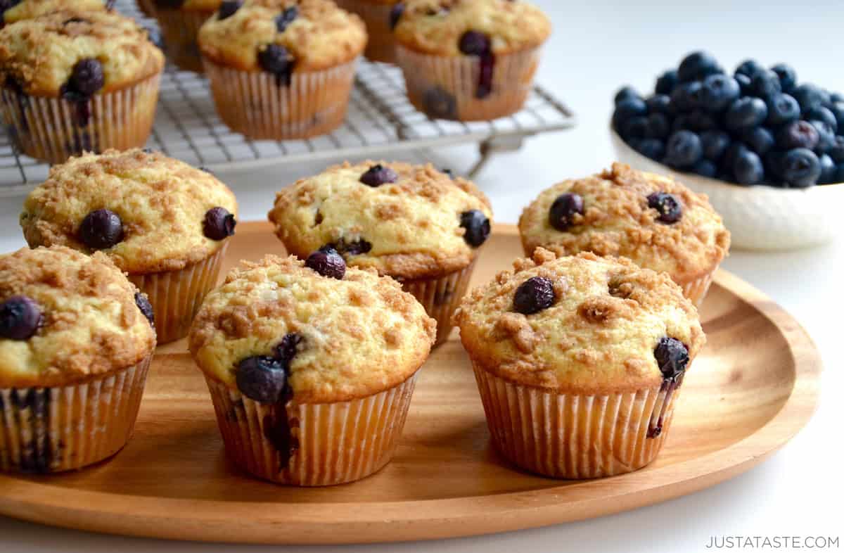 Blueberry crumble muffins on a wood serving plate.