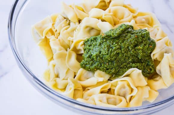 Homemade pistachio pesto atop cooked tortellini pasta