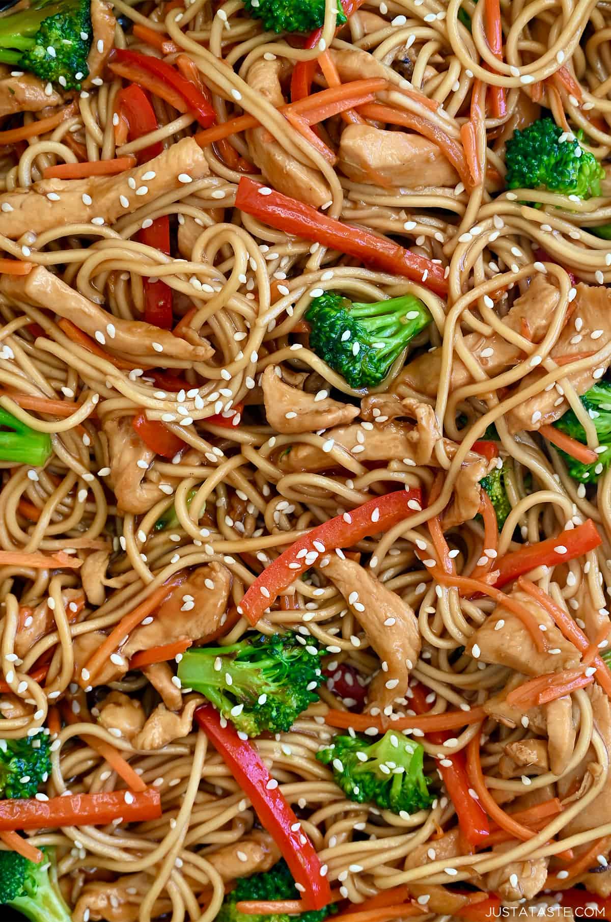Noodles, chicken strips, broccoli florets, shredded carrots and sliced red bell pepper coated in teriyaki sauce and garnished with sesame seeds.