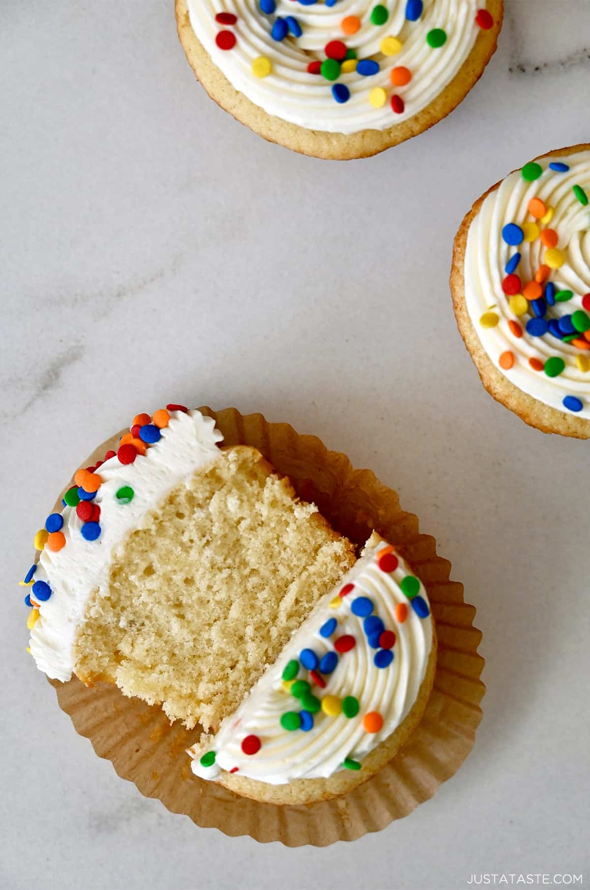A moist cupcake cut in half revealing it's soft and tender crumb.