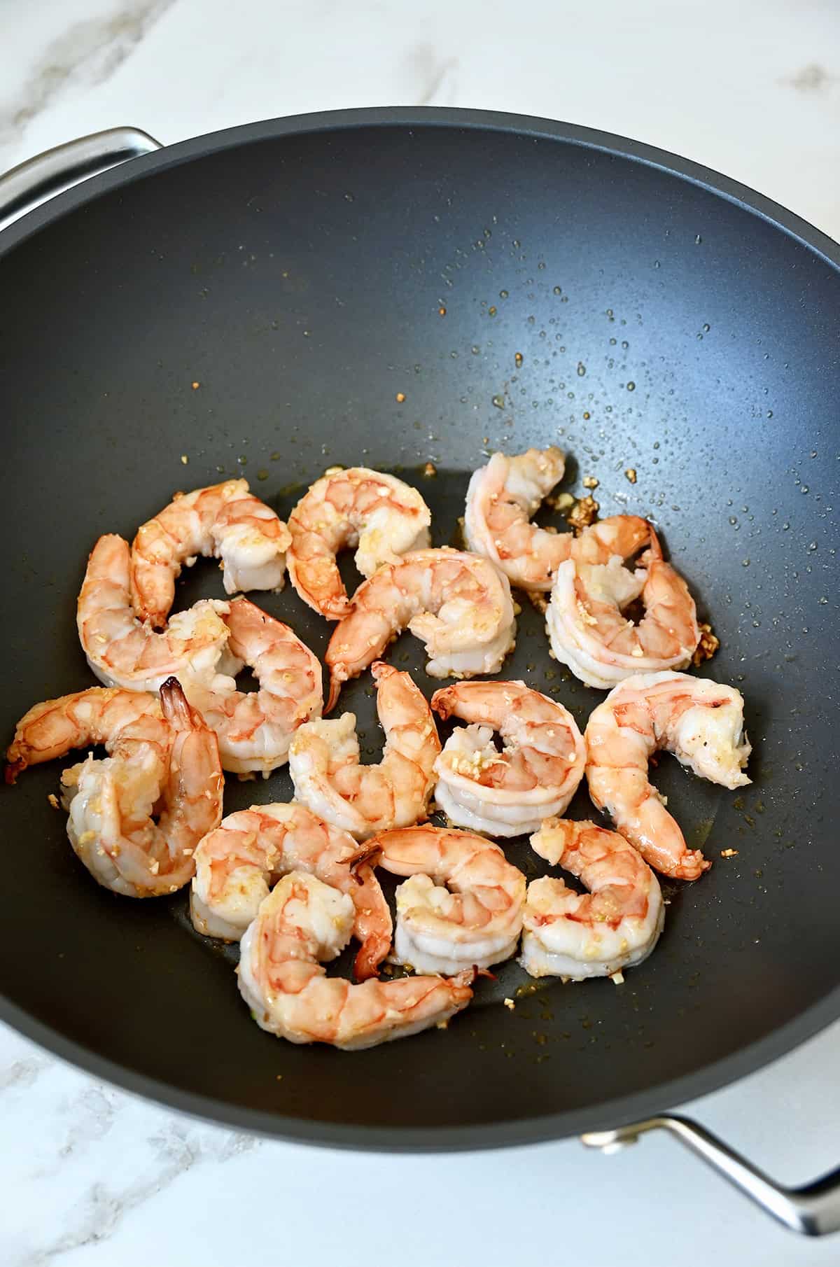 Sautéed shrimp and garlic in a wok.