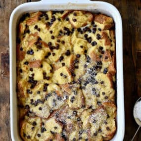 Banana bread pudding with chocolate chips dusted with powdered sugar.