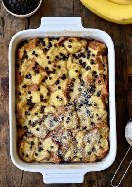 Banana bread pudding with chocolate chips dusted with powdered sugar.