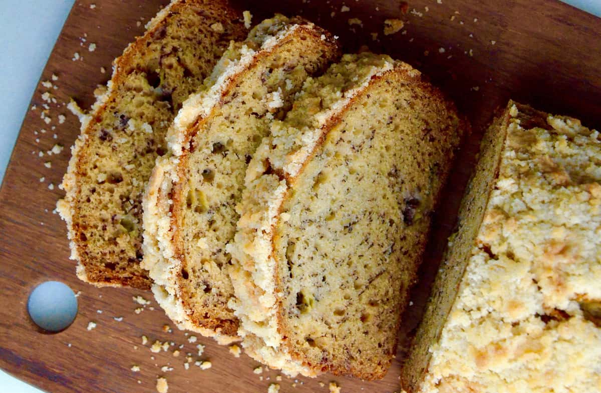 A sliced loaf of banana bread that has a streusel topping.