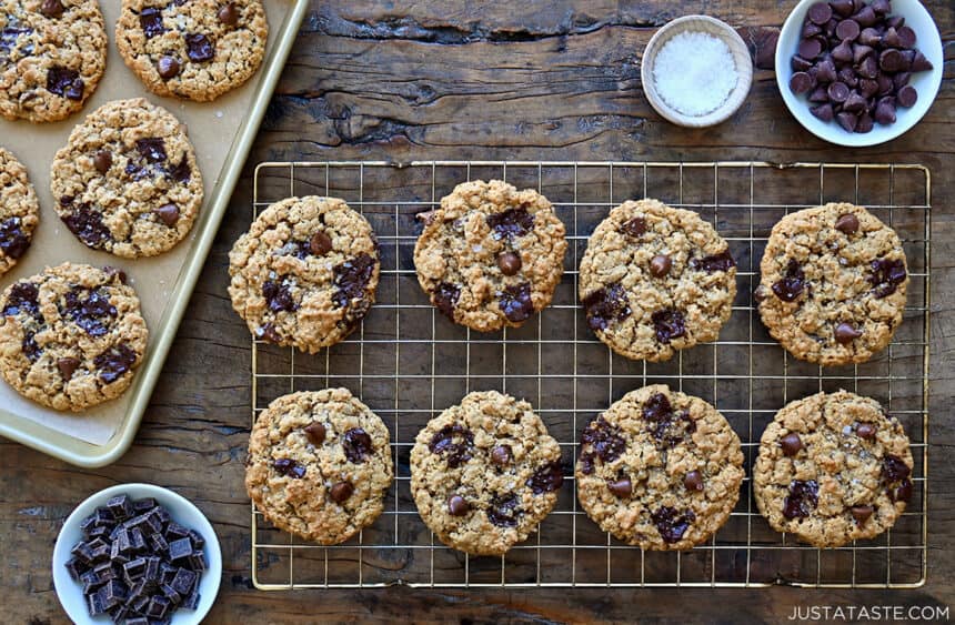 Soft and chewy flourless oatmeal chocolate chip cookies on a wire rack next to cookies on a baking sheet