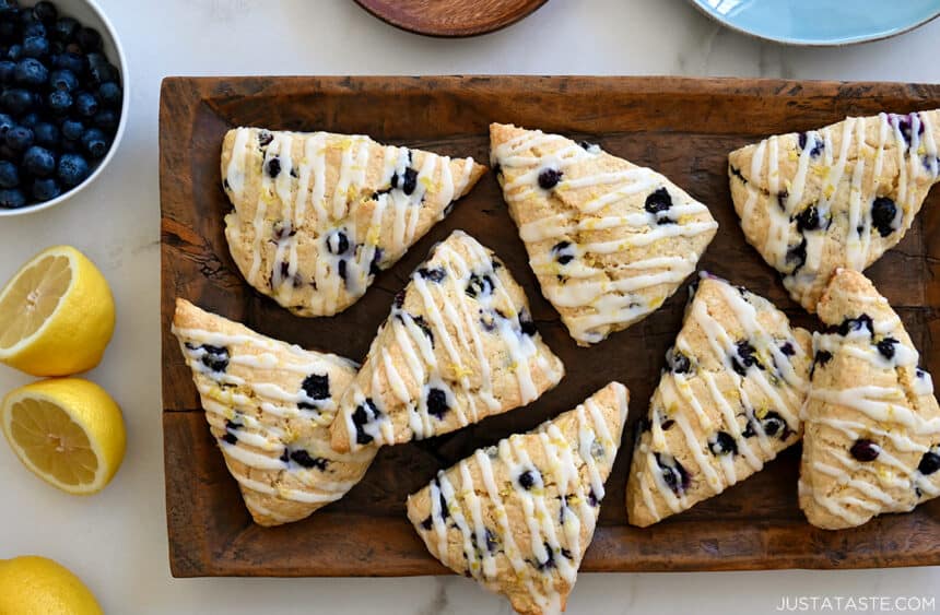 A top-down view of Glazed Lemon Blueberry Scones on a wood serving platter