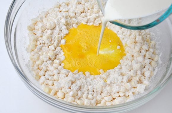 Heavy cream being poured into Quick and Easy Corn Fritters batter