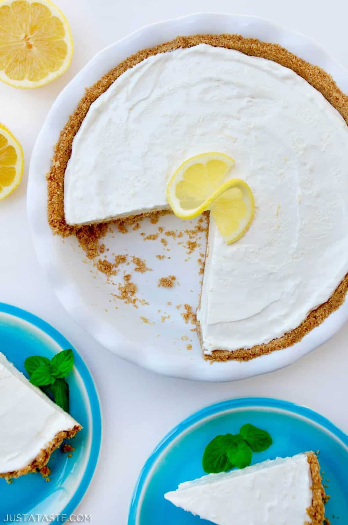 Frozen lemonade pie with a graham cracker crust in a white pie plate.