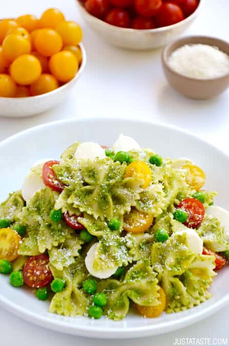 Pea Pesto Pasta Salad topped with fresh mozzarella cheese, cherry tomatoes and Parmesan cheese