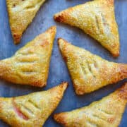 A top-down view of perfectly golden peach turnovers topped with sanding sugar.