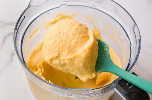 A food processor bowl containing blended frozen yogurt