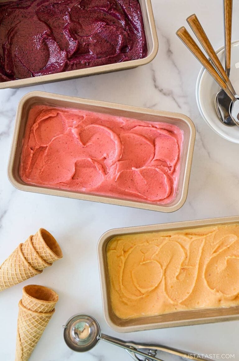 Three flavors of frozen yogurt with cones and an ice cream scoop