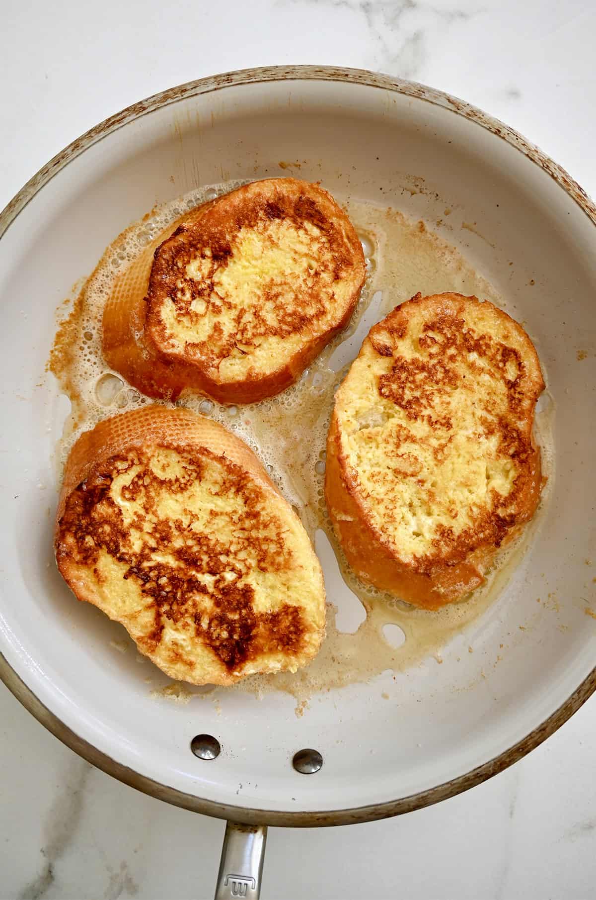 Cooked French toast in a large skillet.