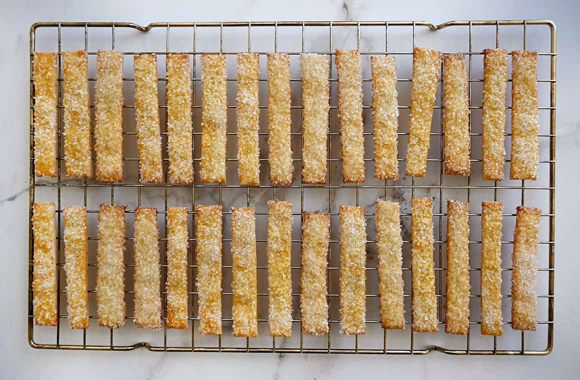 Pie fries topped with sanding sugar cooling on a wire rack