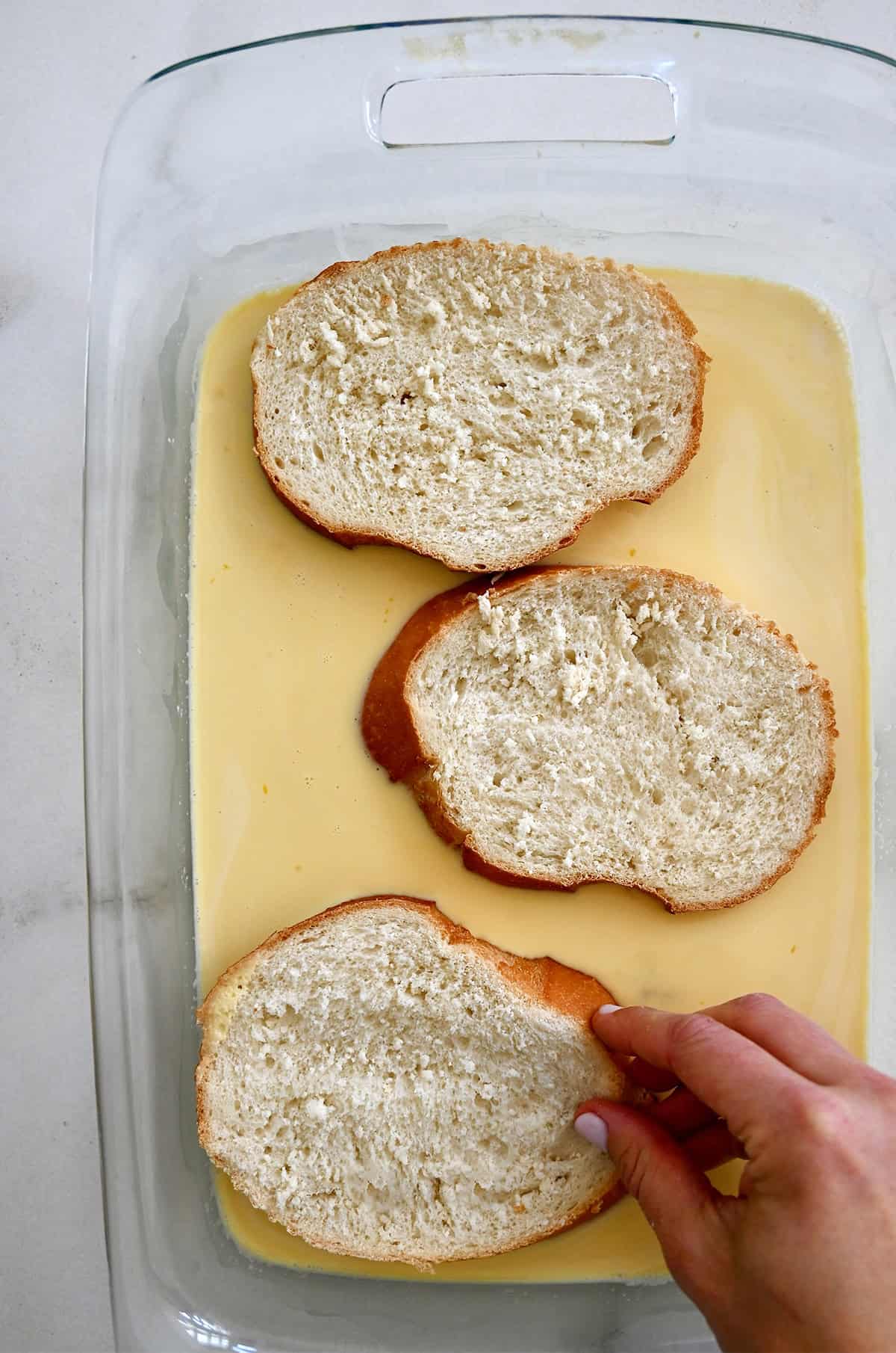 Soaking the first side of bread slices in a honey-sweetened custard.