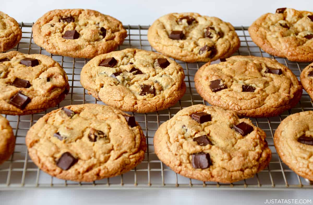 Peanut butter cookies studded with chocolate chunks on a wire cooling rack.