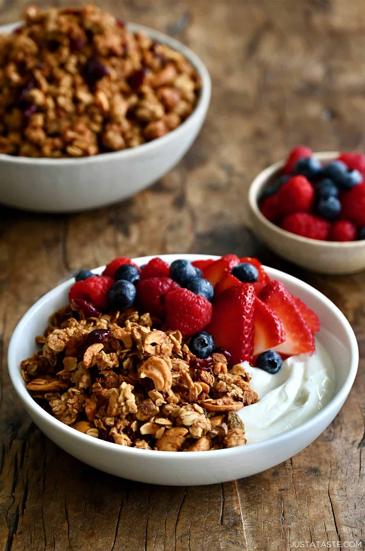 Greek yogurt in a bowl topped with homemade granola and fresh berries.