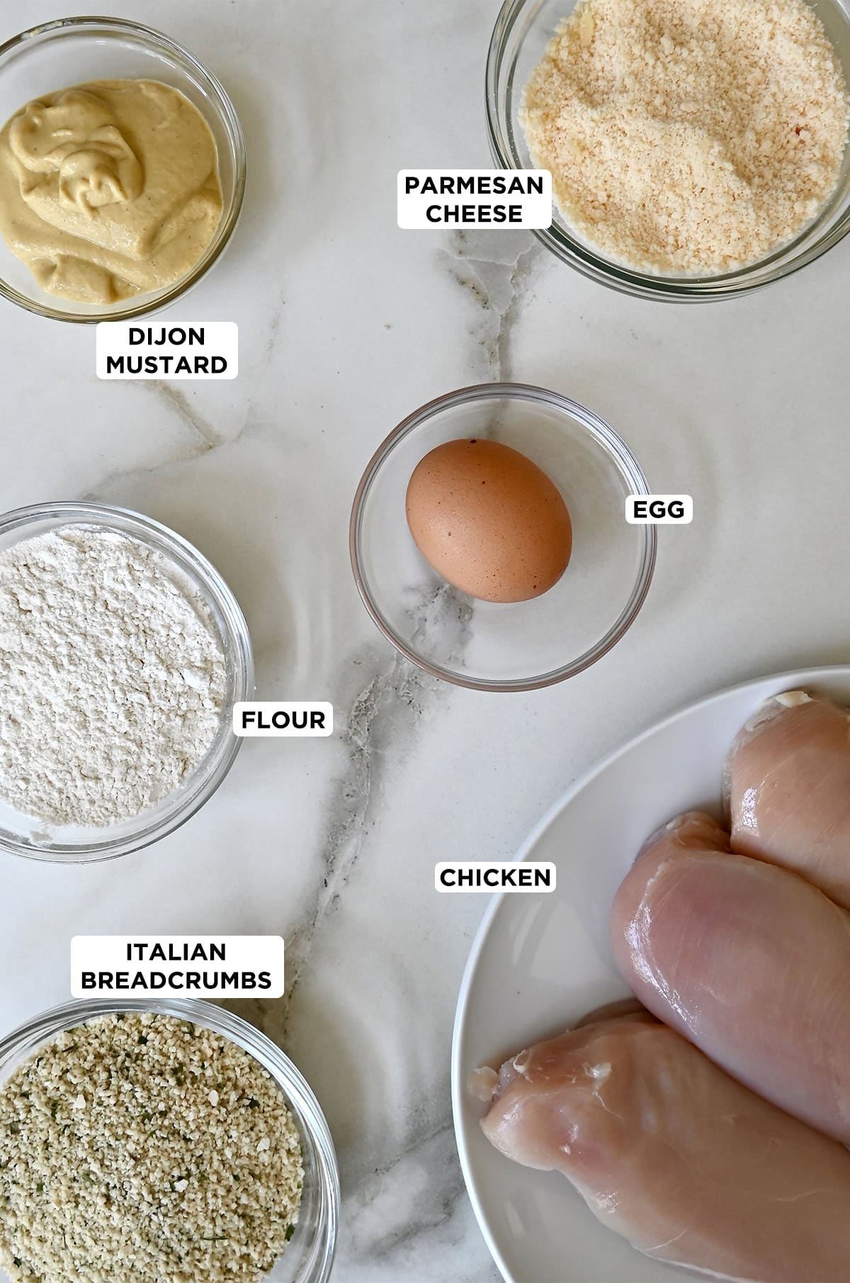 Panko-crusted chicken breast ingredients, including dijon mustard, Parmesan cheese, an egg, chicken breasts, Panko breadcrumbs and flour.
