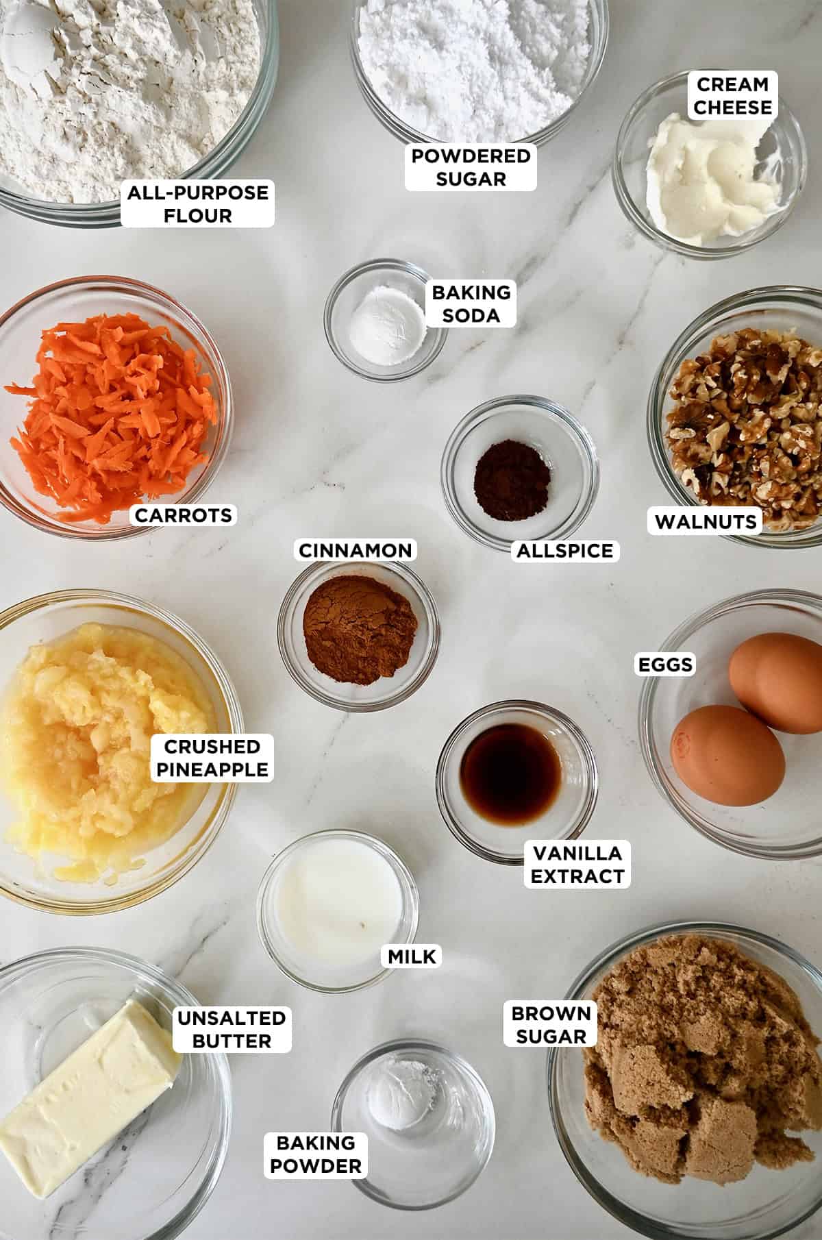 Ingredients to make carrot cake cookies with cream cheese icing in various sizes of glass bowls.