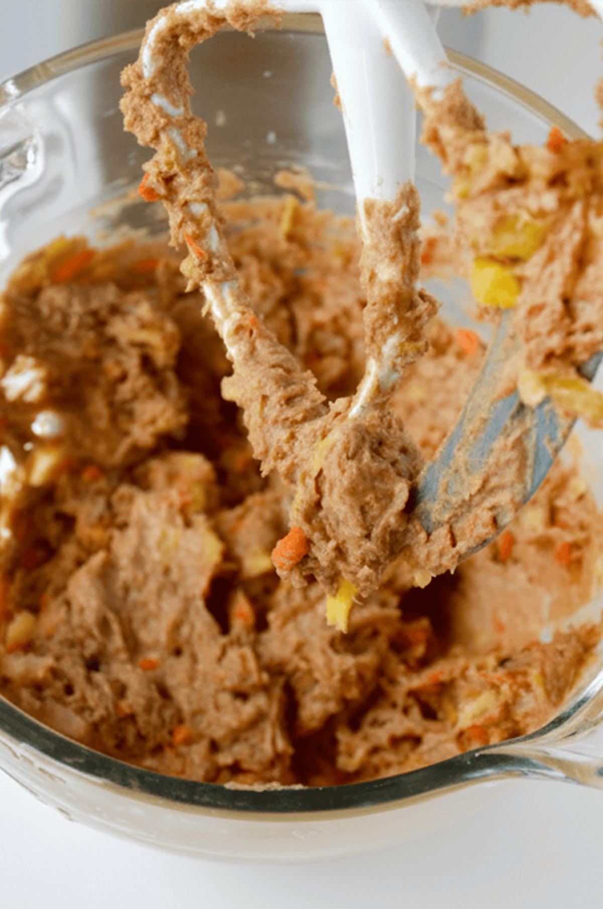 Carrot cake cookie batter in the bowl of stand mixer.