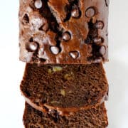 A half-sliced loaf of chocolate banana bread studded with chocolate chips.