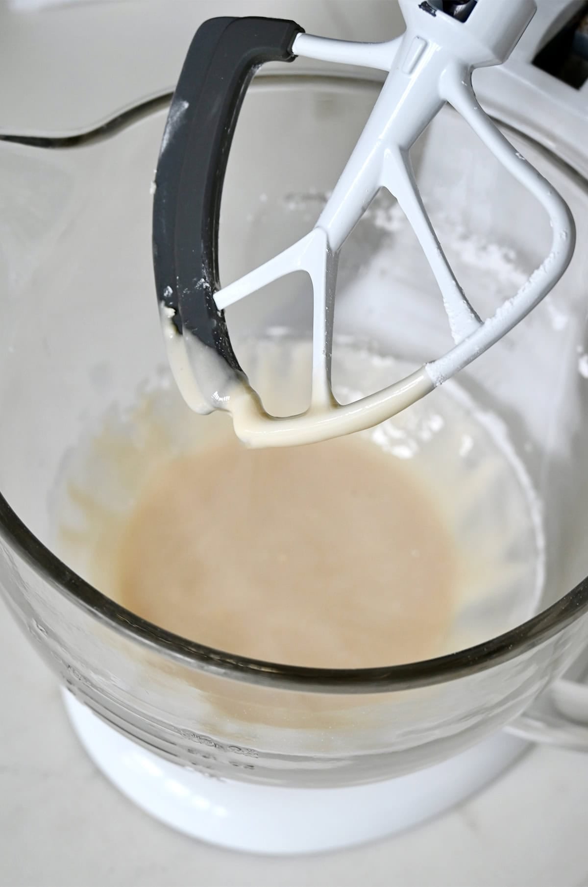 Cream cheese icing in the bowl of a stand mixer.