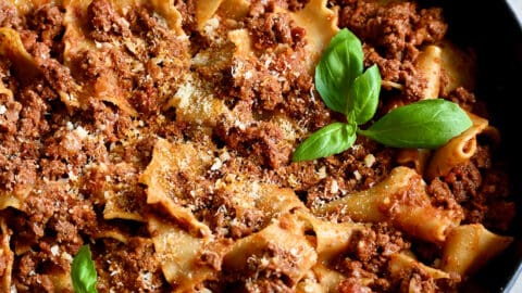Easy skillet lasagna garnished with fresh basil leaves and grated Parmesan cheese.